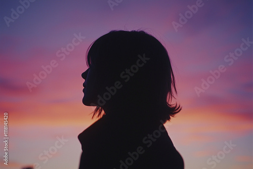 Silhouette of a person against a vibrant sunset sky