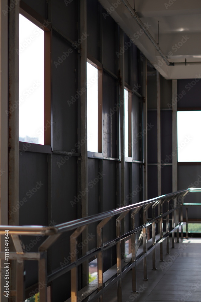 The balcony of a minimalist building with morning sunlight hitting the railing and wooden floors The balcony of a minimalist building with morning sunlight hitting the railing and wooden floors