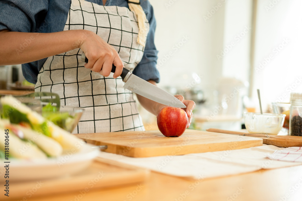 A woman cutting an apple in the kitchen A woman cutting an apple in the kitchen
