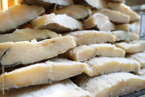 A stack of traditional dried and salted codfish (bacalhau) on display, ready for use in authentic Portuguese and Mediterranean dishes. photo