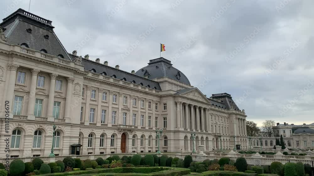 Belgian flag is waiving on top of the Royal Palace of Brussels. It is the official palace of the Belgian Royal family in the city centre. Front facade. Bruxelles, Brussels capital region, Belgium Belgian flag is waiving on top of the Royal Palace of Brussels. It is the official palace of the Belgian Royal family in the city centre. Front facade. Bruxelles, Brussels capital region, Belgium
