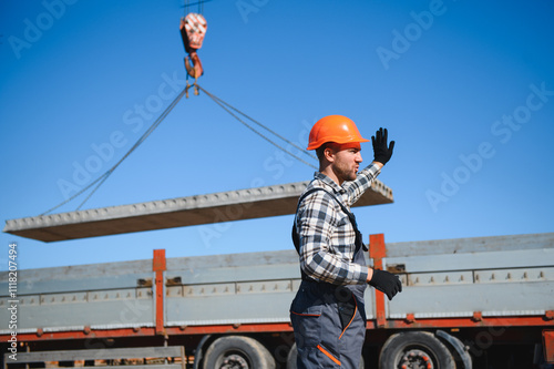 Fotografia A builder controls a crane while unloading panels to cover a house