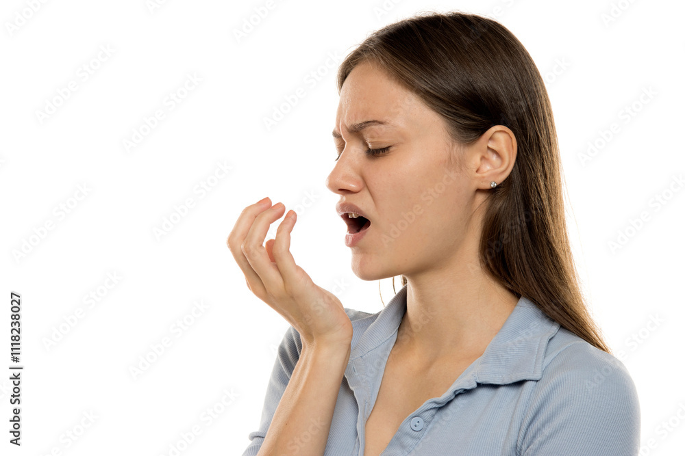 young woman checking her breath with her hand. young woman checking her breath with her hand.