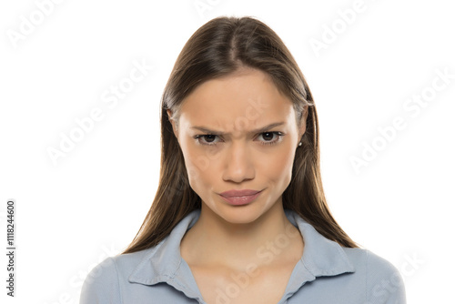 Portrait of a beautiful young angry woman with makeup on a white studio background