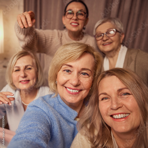 Selfie portrait of five cheerful, smiling elderly women, friends, taking selfie, meeting at home for cozy celebrations and wine drinking. Concept of elderly lifestyle, positive emotions