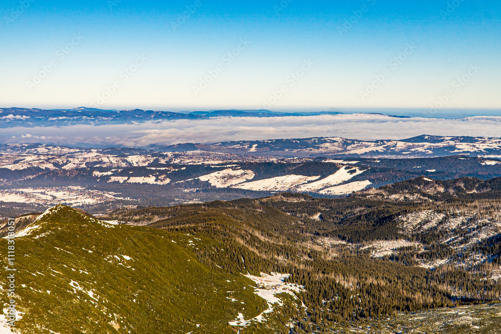 Panorama ze szczytu Pradziada w Czechach zimą. Piękna pogoda z mgłami w dolinach.