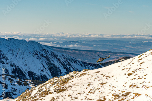 Obraz na płótnie Góry Tatry zimą i widoczny latający helikopter w salonie