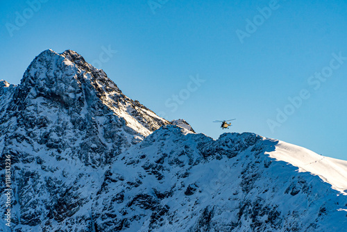 Góry Tatry zimą i widoczny latający helikopter photo