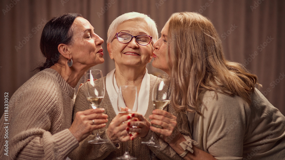 Happy Mothers day. Two elderly women, daughter's greeting their old mother with her day, drinking wine, laughing, showing respect and love. Concept of elderly lifestyle, positive emotions Happy Mothers day. Two elderly women, daughter's greeting their old mother with her day, drinking wine, laughing, showing respect and love. Concept of elderly lifestyle, positive emotions