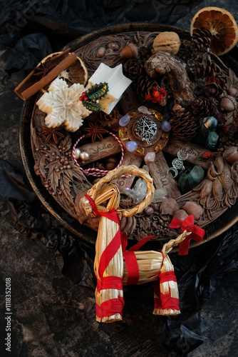 Wiccan altar for Yule holiday. Wheel of the year, Yule goat, amulets, crystals, cones, decorations on dark table close up. Esoteric Ritual for Yule, Magical Winter Solstice, witchcraft. top view