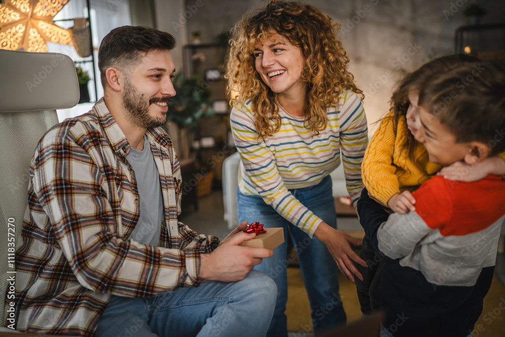 Obraz premium Mum and children surprise dad with gift while he work from home