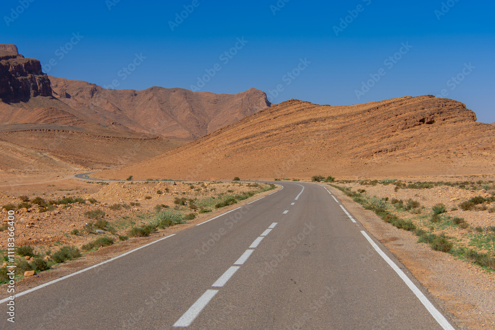 Long road through the Moroccan desert along the Atlas Mountains Long road through the Moroccan desert along the Atlas Mountains