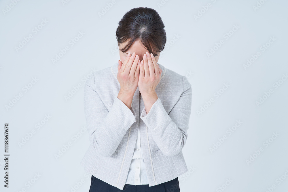 両手で顔を覆う女性