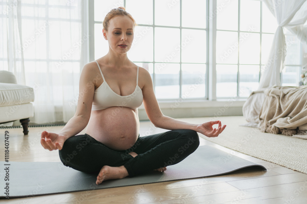 Pregnancy prenatal breathing. Pregnant woman with big belly sitting in lotus pose on yoga matt at home. Pregnant girl practicing yoga mindfulness meditation. Relaxation self care during pregnancy Pregnancy prenatal breathing. Pregnant woman with big belly sitting in lotus pose on yoga matt at home. Pregnant girl practicing yoga mindfulness meditation. Relaxation self care during pregnancy