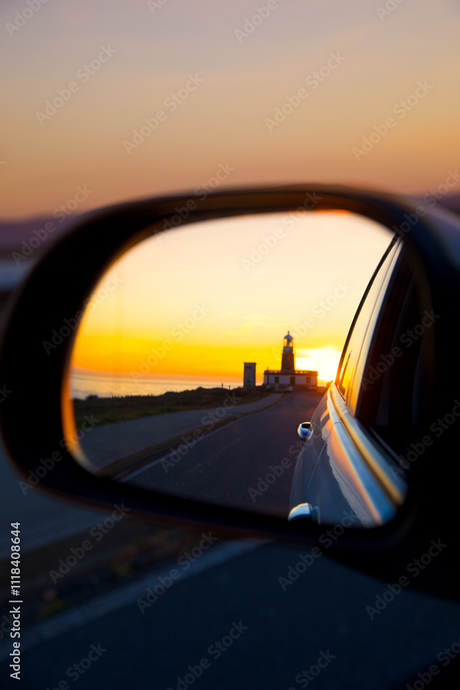 Fototapeta premium Sunset lighthouse reflections. Lighhouse in the rock 