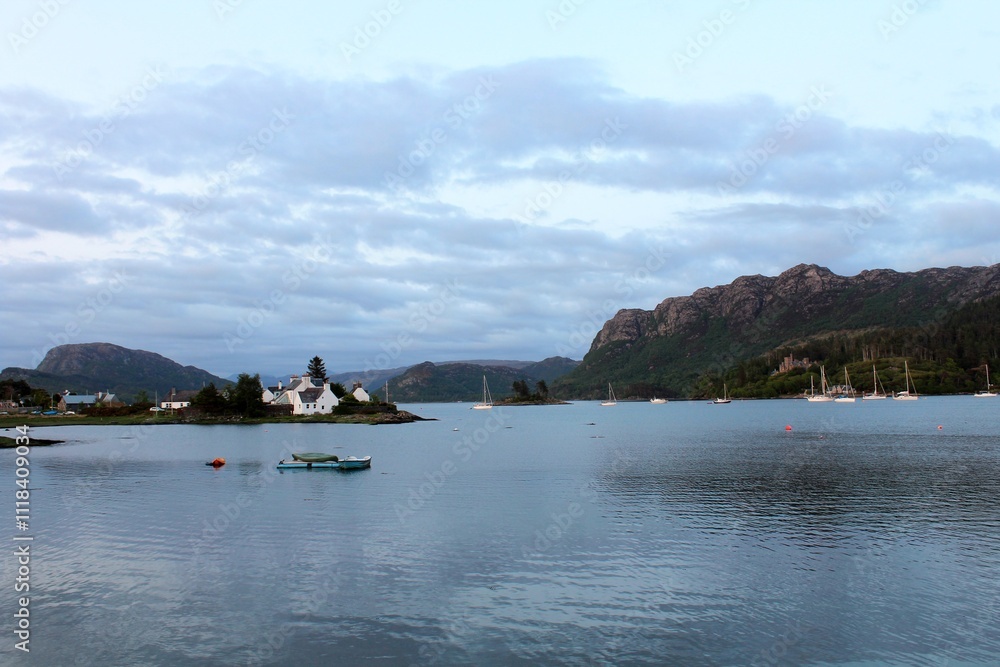 A view of the beautiful small Scottish highlands town of Plockton, with flowers along the road, along the waters of Loch Carron,in Scotland, United Kingdom A view of the beautiful small Scottish highlands town of Plockton, with flowers along the road, along the waters of Loch Carron,in Scotland, United Kingdom