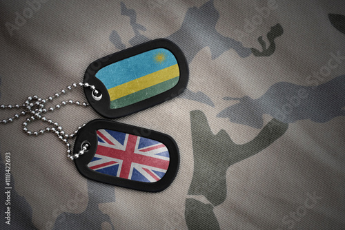 army blank, dog tag with national flag of rwanda and great britain on the khaki texture background. military concept. photo