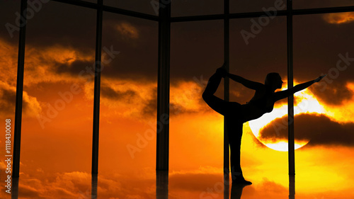 girl does yoga pose on the roof of a sludgy skyscraper at sunset 