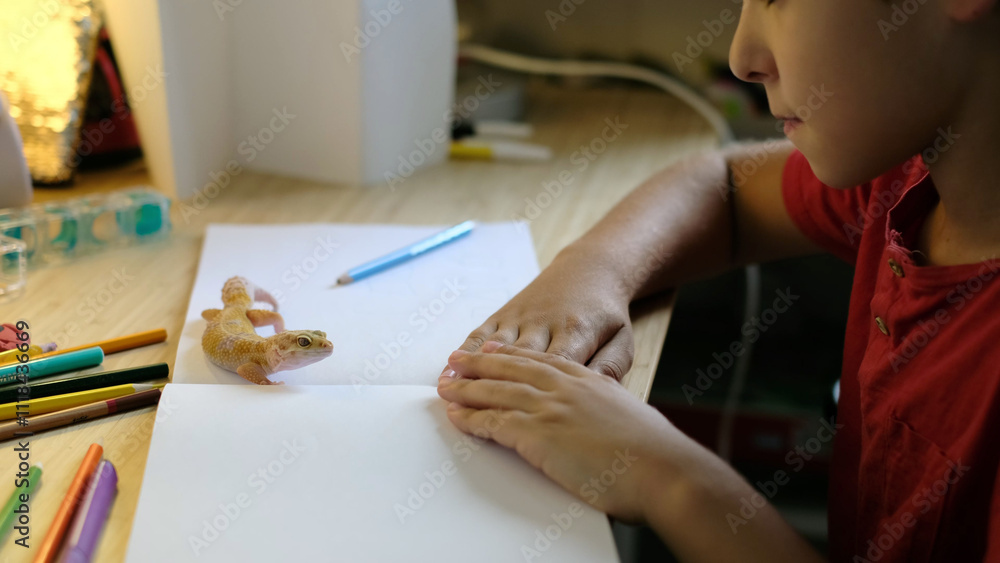 A gecko explores a desk while a child leans in with curiosity, surrounded by colorful pencils and a blank page. This photo reflects calm observation and the integration of learning with nature. A gecko explores a desk while a child leans in with curiosity, surrounded by colorful pencils and a blank page. This photo reflects calm observation and the integration of learning with nature.