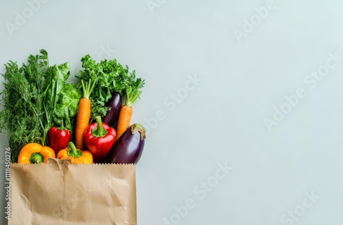 A paper bag filled with fresh vegetables like carrots, peppers, and eggplant. photo