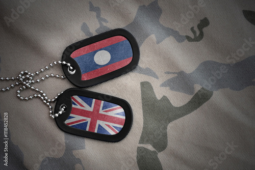 army blank, dog tag with national flag of laos and great britain on the khaki texture background. military concept. photo