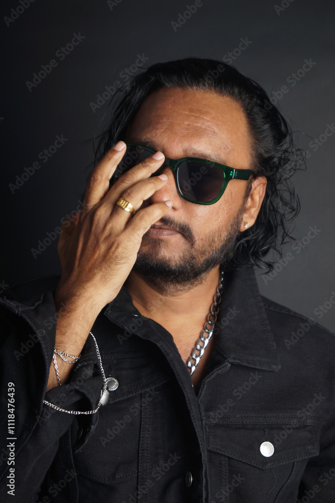 Obraz premium Gangster Boss wearing sunglasses, holding his hand, ring finger, black shirt, isolated over black background, stock images.