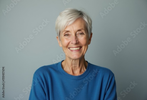 Smiling older woman with short gray hair wearing a blue sweater