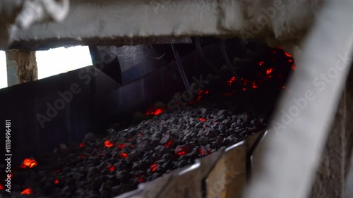 A cement factory featuring a conveyor transporting fired hot stones and gravel through a tunnel on the conveyor system.