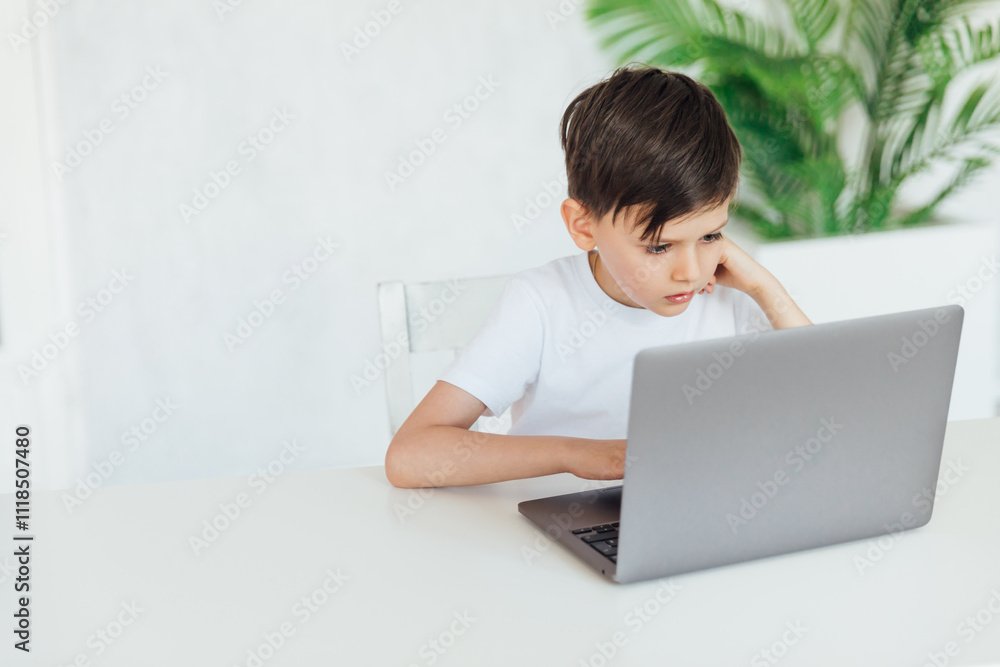 Boy Studying Playing On Laptop Online At Table Boy Studying Playing On Laptop Online At Table