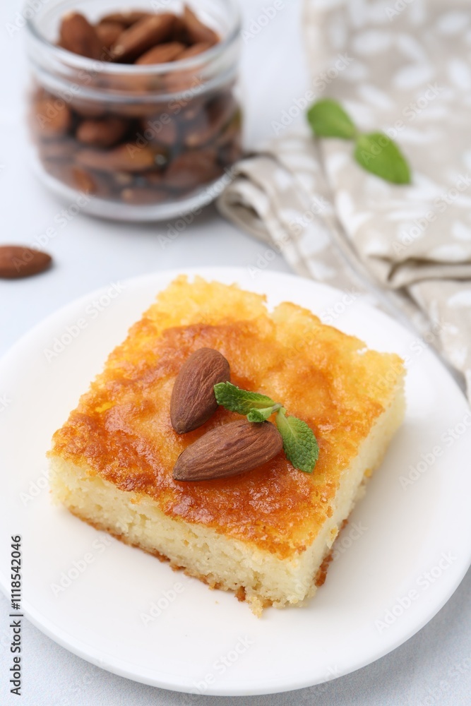 Slice of tasty semolina cake served on white tiled table, closeup Slice of tasty semolina cake served on white tiled table, closeup