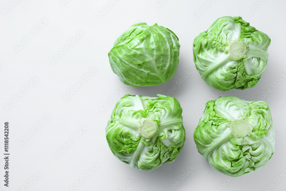 Fototapeta premium Raw green cabbages on white background, flat lay. Space for text