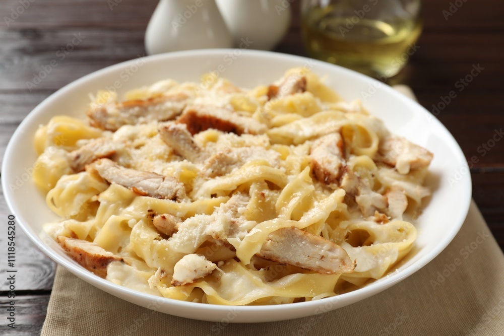 Tasty Alfredo pasta with chicken on wooden table, closeup Tasty Alfredo pasta with chicken on wooden table, closeup