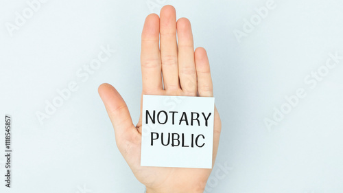 Adhesive paper on the palm of the hand with the text Notary Publi photo