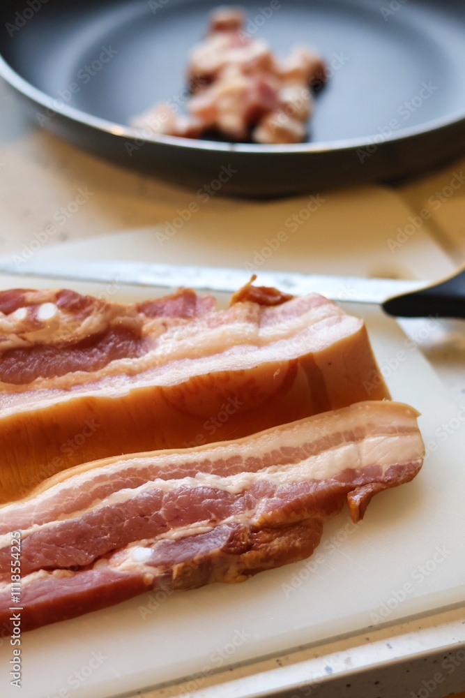 Close-up of bacon during the preparation, cutting and cooking process Close-up of bacon during the preparation, cutting and cooking process