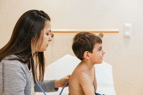 Doctor examining child's lungs with stethoscope during respiratory physiotherapy session