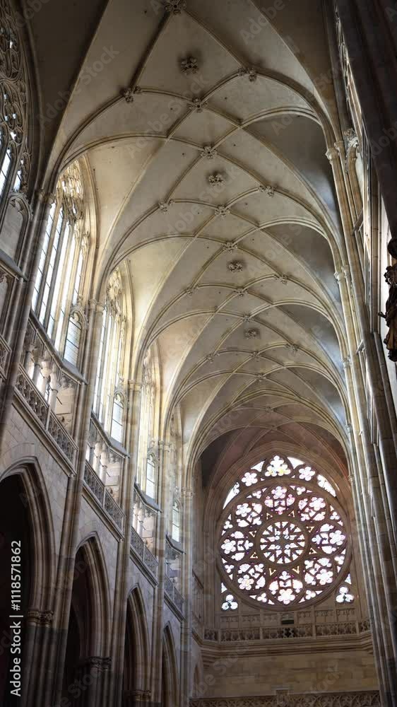 A breathtaking view of a Gothic cathedral’s vaulted ceiling, adorned with ribbed arches and floral details. The grand rose window at the far end bathes the space in colorful light, enhancing its ether A breathtaking view of a Gothic cathedral’s vaulted ceiling, adorned with ribbed arches and floral details. The grand rose window at the far end bathes the space in colorful light, enhancing its ether