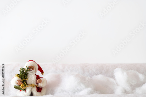 Santa Claus in red fur wading through deep snow to deliver Christmas presents with white background and room for copy