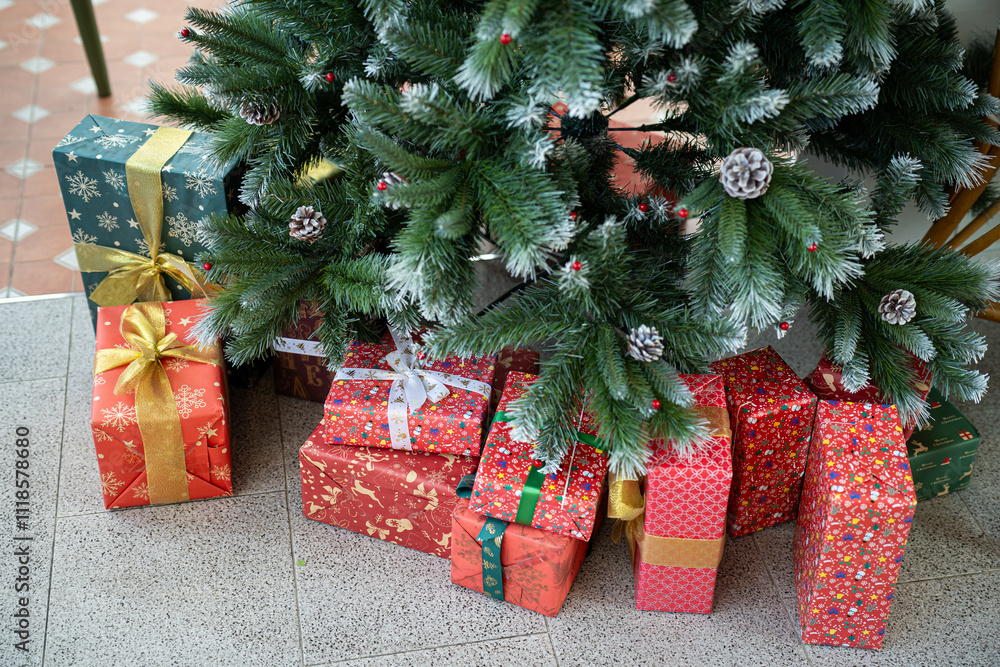 Merry x-mas,Close up of multiple gift boxes,Colorful balls and Christmas greeting picture parcel,Santa doll decoration on Green Christmas tree background Decoration During Christmas and New Year.