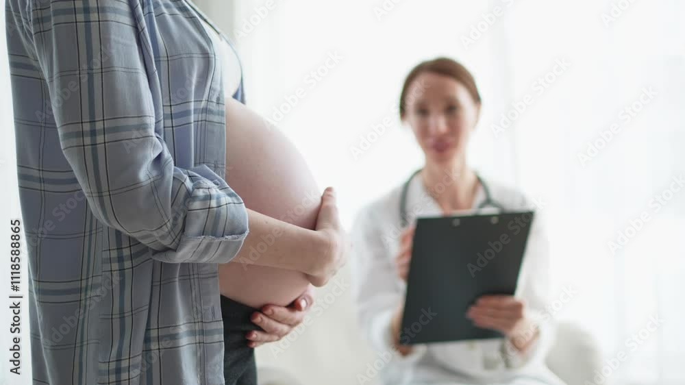 Pregnant woman hands touching big belly in doctor office. Female doctor examining pregnant woman. Gynecologist doctor consulting patient about pregnancy in hospital. Visit to doctor medical checkup Pregnant woman hands touching big belly in doctor office. Female doctor examining pregnant woman. Gynecologist doctor consulting patient about pregnancy in hospital. Visit to doctor medical checkup