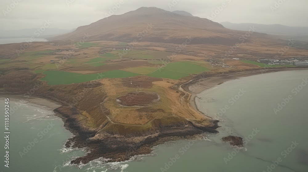 Aerial view of coastal landscape with rugged terrain, rolling hills, and a secluded bay. Aerial view of coastal landscape with rugged terrain, rolling hills, and a secluded bay.