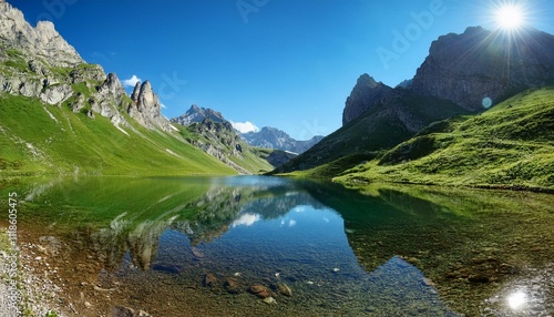 nestled in the mountains the tranquil lake mirrors the jagged peaks and vibrant greenery creating a picturesque scene under the bright sun