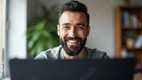 Smiling corporate trainer with a trimmed beard enjoying a video session at home