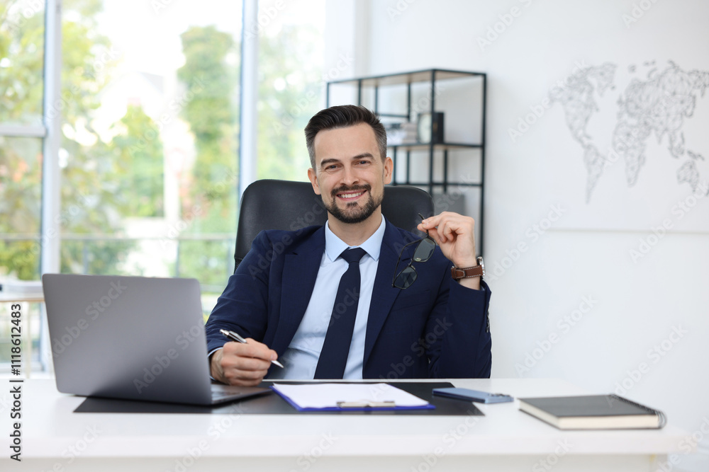 Portrait of smiling banker at table in office Portrait of smiling banker at table in office