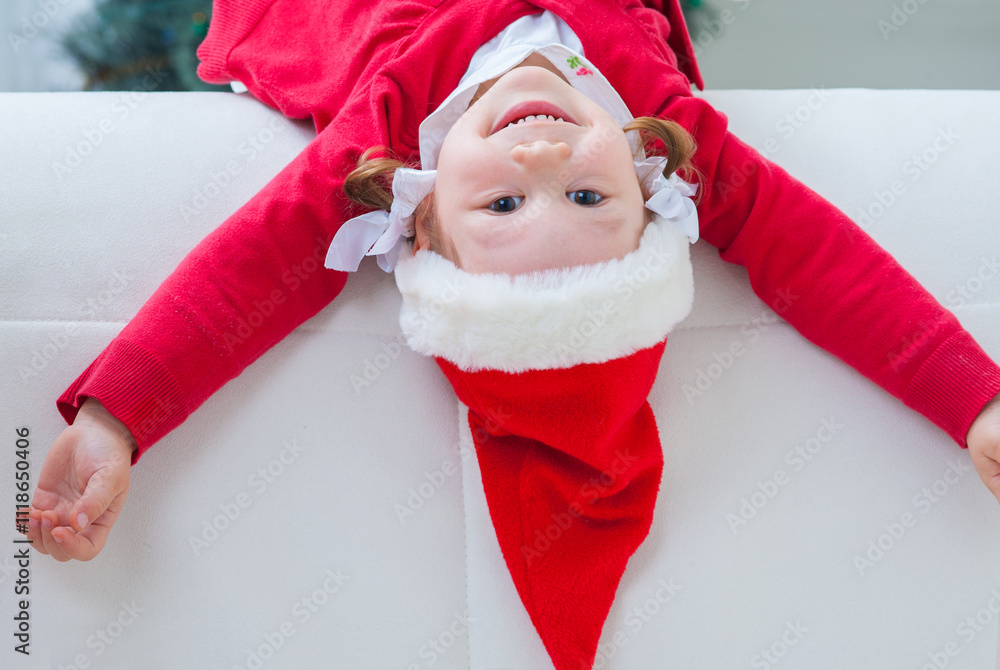Portrait of little cute girl in Santa Claus costume in Christmas