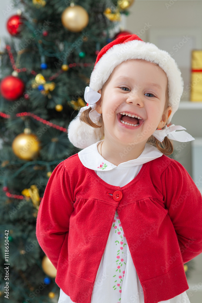 Portrait of little cute girl in Santa Claus costume with Christmas present