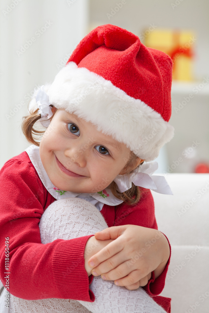 Portrait of little cute girl in Santa Claus costume in Christmas