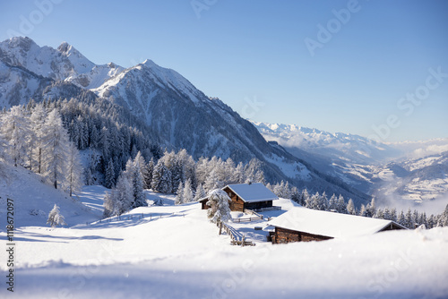 Winter nature landscape with snow covered authentic hut in the Alps. Winter wonderland concept
