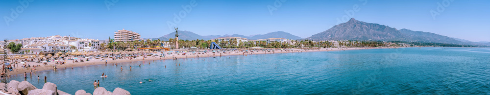 Tourists relaxing on the beach of Estepona, Spain, with concha mountain looming. PUERTO BANUS, MARBELLA Tourists relaxing on the beach of Estepona, Spain, with concha mountain looming. PUERTO BANUS, MARBELLA