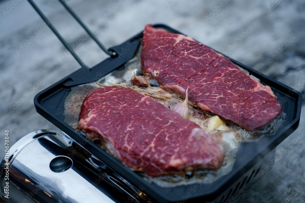 Meat roasting on fire, cooking steak on a pan in nature on a hike