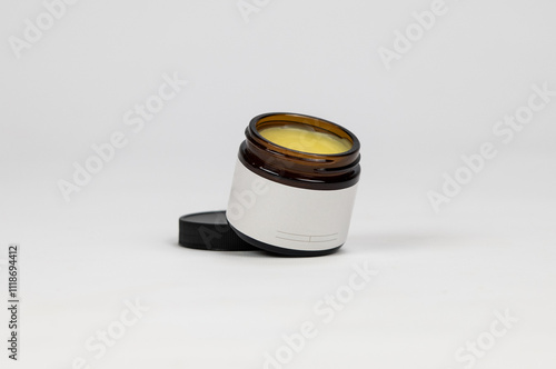 Blank label on amber salve cosmetic jar white background